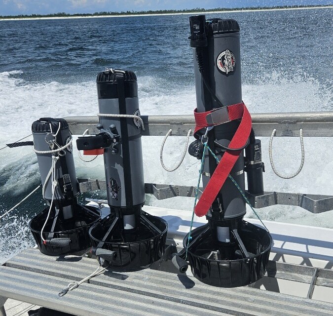 Three Dive Xtras BlackTip scooters racked on a boat headed offshore